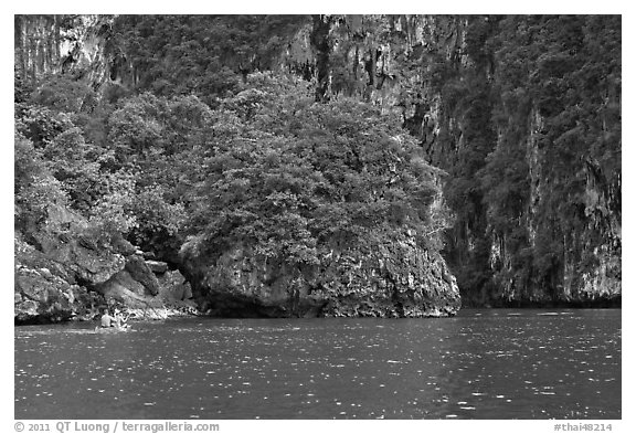 Couple paddling below steep cliffs. Krabi Province, Thailand