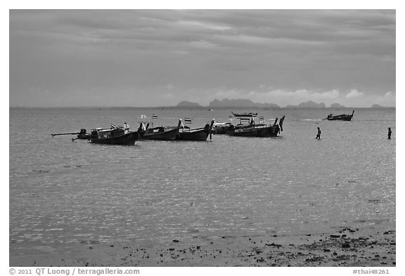 Boats anchored at low tide, storm sky,  Railay East. Krabi Province, Thailand