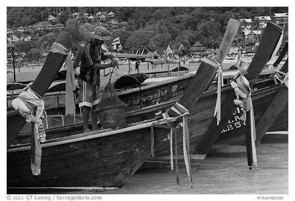 Row of boats, fisherman standing, Ko Phi Phi. Krabi Province, Thailand (black and white)