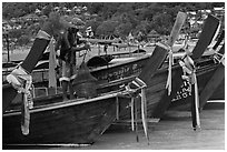 Row of boats, fisherman standing, Ko Phi Phi. Krabi Province, Thailand ( black and white)