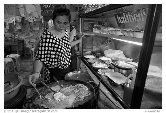 Woman adding spices to Pad Thai, Ko Phi-Phi island. Krabi Province, Thailand (black and white)