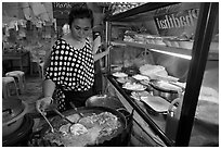 Woman adding spices to Pad Thai, Ko Phi-Phi island. Krabi Province, Thailand (black and white)