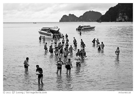 Asian tourists wading in water, Ko Phi Phi. Krabi Province, Thailand (black and white)