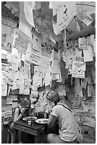 Women eating at Pad Thai restaurant decorated with customer notes, Ko Phi-Phi Don. Krabi Province, Thailand ( black and white)