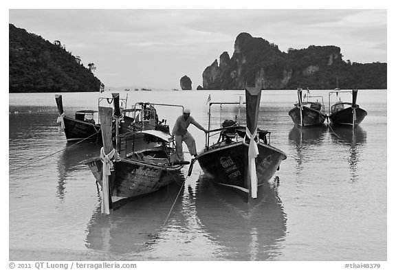 Man stepping on boats, Ao Lo Dalam, Ko Phi-Phi Don. Krabi Province, Thailand (black and white)