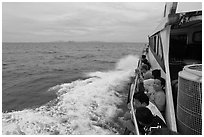 Passengers sitting on side of boat. Krabi Province, Thailand ( black and white)