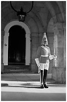 Horseguard standing in front of door. London, England, United Kingdom ( black and white)