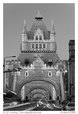 Traffic under arches of the Tower Bridge at twilight. London, England, United Kingdom (black and white)