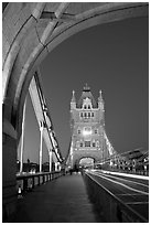 Walkway and road traffic on the Tower Bridge at night. London, England, United Kingdom ( black and white)