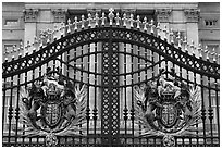 Entrance grids of Buckingham Palace with royalty emblems. London, England, United Kingdom (black and white)