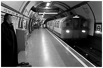 Man waiting for approaching train at Hyde Park subway station. London, England, United Kingdom ( black and white)