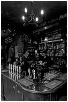 Woman cleaning glass at the bar, pub The Grenadier. London, England, United Kingdom (black and white)