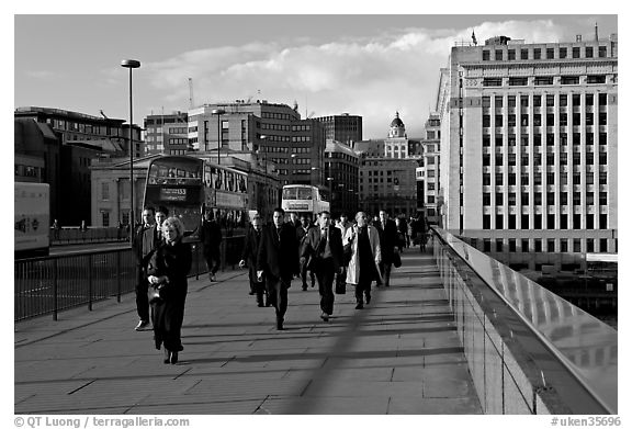 Office workers pouring out of the city of London across London Bridge, late afternoon. London, England, United Kingdom (black and white)