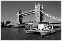 Fast catamaran cruising the Thames, with Tower Bridge in the background. London, England, United Kingdom ( black and white)