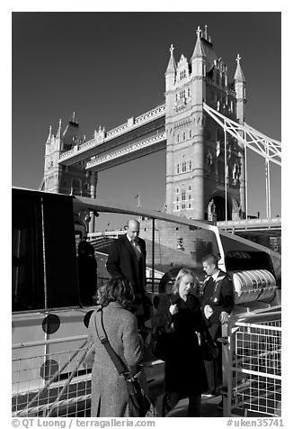 Passengers disembarking a boat in their morning commute, Tower Bridge in the background. London, England, United Kingdom (black and white)