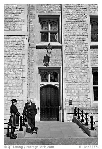 Yeoman Warder talking with man in suit in front of the Jewel House, Tower of London. London, England, United Kingdom (black and white)