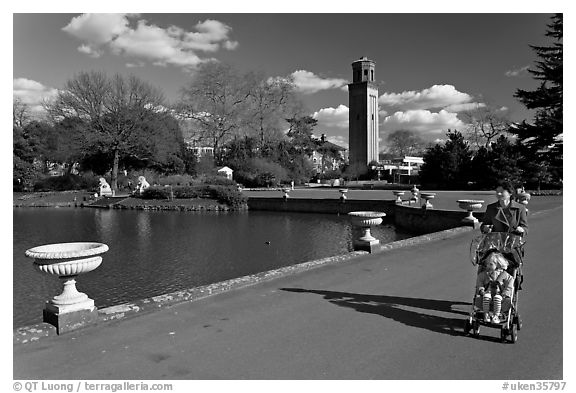 Woman pushing stroller next to the lake. Kew Royal Botanical Gardens,  London, England, United Kingdom