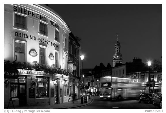 Tavern, moving double decker bus, and church at night. Greenwich, London, England, United Kingdom