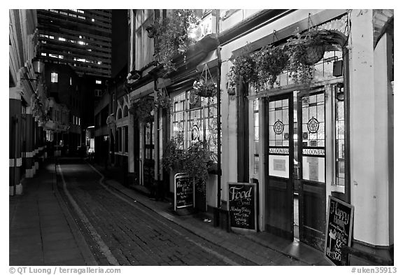 Saloon bar and cobblestone alley at night. London, England, United Kingdom (black and white)