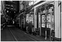Saloon bar and cobblestone alley at night. London, England, United Kingdom (black and white)