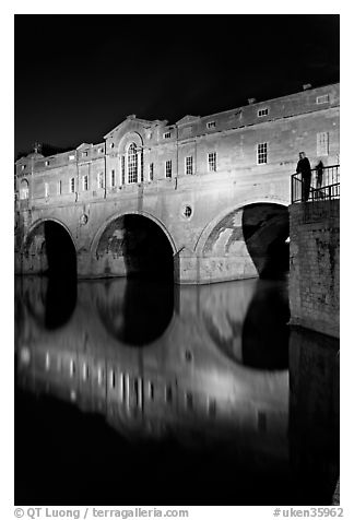 Man looking at the Pulteney Bridge  at night. Bath, Somerset, England, United Kingdom (black and white)