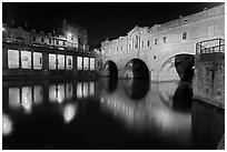 Pulteney Bridge, and quay reflected in River Avon at night. Bath, Somerset, England, United Kingdom (black and white)