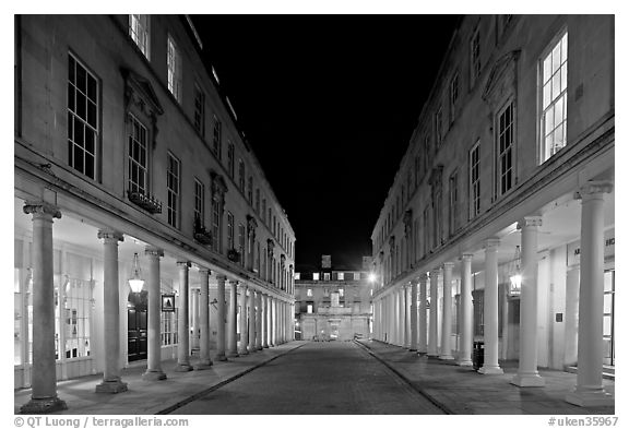 Street bordered by colonades at night. Bath, Somerset, England, United Kingdom (black and white)