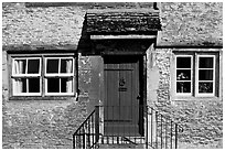 Windows and doorway entrance of stone house, Lacock. Wiltshire, England, United Kingdom (black and white)