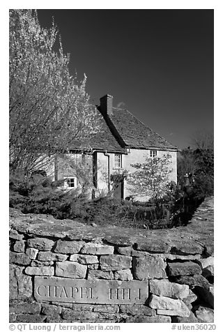 Stone wall with engraved street name, yard and house, Lacock. Wiltshire, England, United Kingdom (black and white)