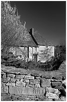 Stone wall with engraved street name, yard and house, Lacock. Wiltshire, England, United Kingdom (black and white)