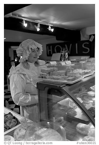 Woman wearing old-fashioned attire in a bakery, Lacock. Wiltshire, England, United Kingdom (black and white)