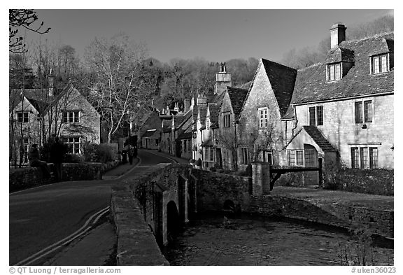 Packbridge crossing the Bybrook River and main street, Castle Combe. Wiltshire, England, United Kingdom (black and white)