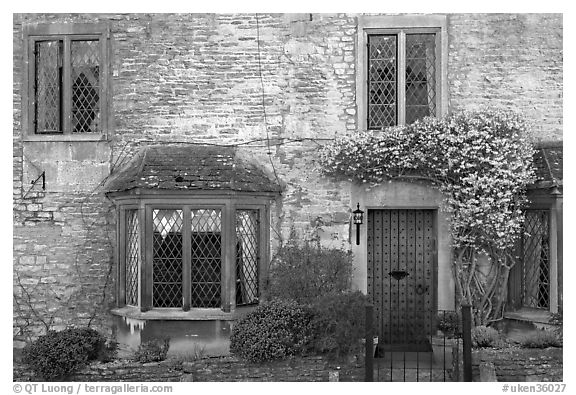 Stone house facade with flowers, Castle Combe. Wiltshire, England, United Kingdom (black and white)