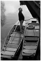 Man standing in a rowboat, old town moat. Canterbury,  Kent, England, United Kingdom (black and white)