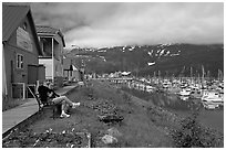 Couple sitting on bench by the harbor. Whittier, Alaska, USA (black and white)