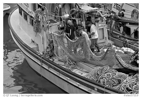 Fishermen repairing nets on fishing boat. Whittier, Alaska, USA (black and white)