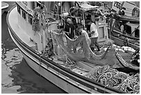 Fishermen repairing nets on fishing boat. Whittier, Alaska, USA ( black and white)