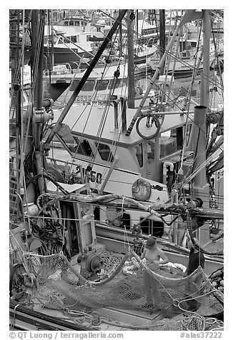 Man and woman repairing nets on fishing boat. Whittier, Alaska, USA (black and white)