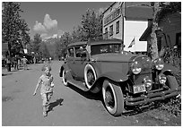 Girl on main street with red classic car. McCarthy, Alaska, USA ( black and white)