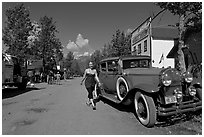 Woman walking next to red classic car. McCarthy, Alaska, USA ( black and white)