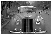 Rolls Royce on dirt road with mountain bikers in background. McCarthy, Alaska, USA (black and white)