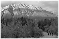 People strolling on unpaved road at sunset. McCarthy, Alaska, USA (black and white)