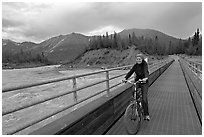 Woman on mountain bike crossing the footbridge. McCarthy, Alaska, USA ( black and white)