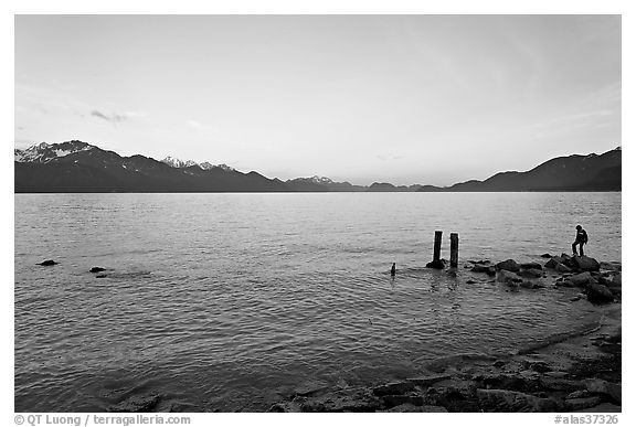 Boy standing in front of Resurrection Bay, sunset. Seward, Alaska, USA