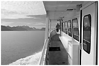 Passenger standing outside tour boat. Seward, Alaska, USA (black and white)