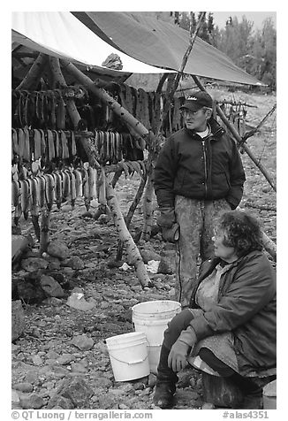 Inupiaq Eskimo man and woman next to fish hung for drying, Ambler. North Western Alaska, USA