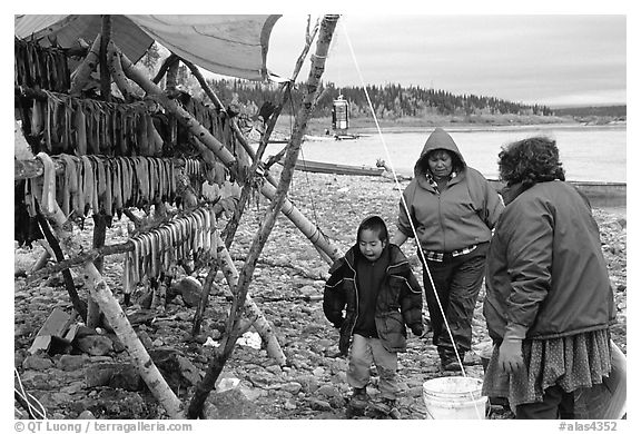 Inupiaq Eskimo family with stand of dried fish, Ambler. North Western Alaska, USA (black and white)