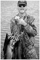 Fisherman carrying salmon freshly caught in the Fishing Hole. Homer, Alaska, USA (black and white)