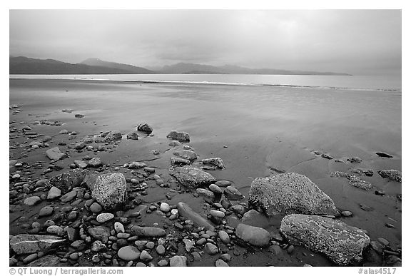 Sandy beach, rocks, and stormy skies on the Bay. Homer, Alaska, USA