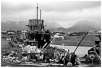Retired fishing boat with a pile of marine gear on the Spit. Homer, Alaska, USA (black and white)